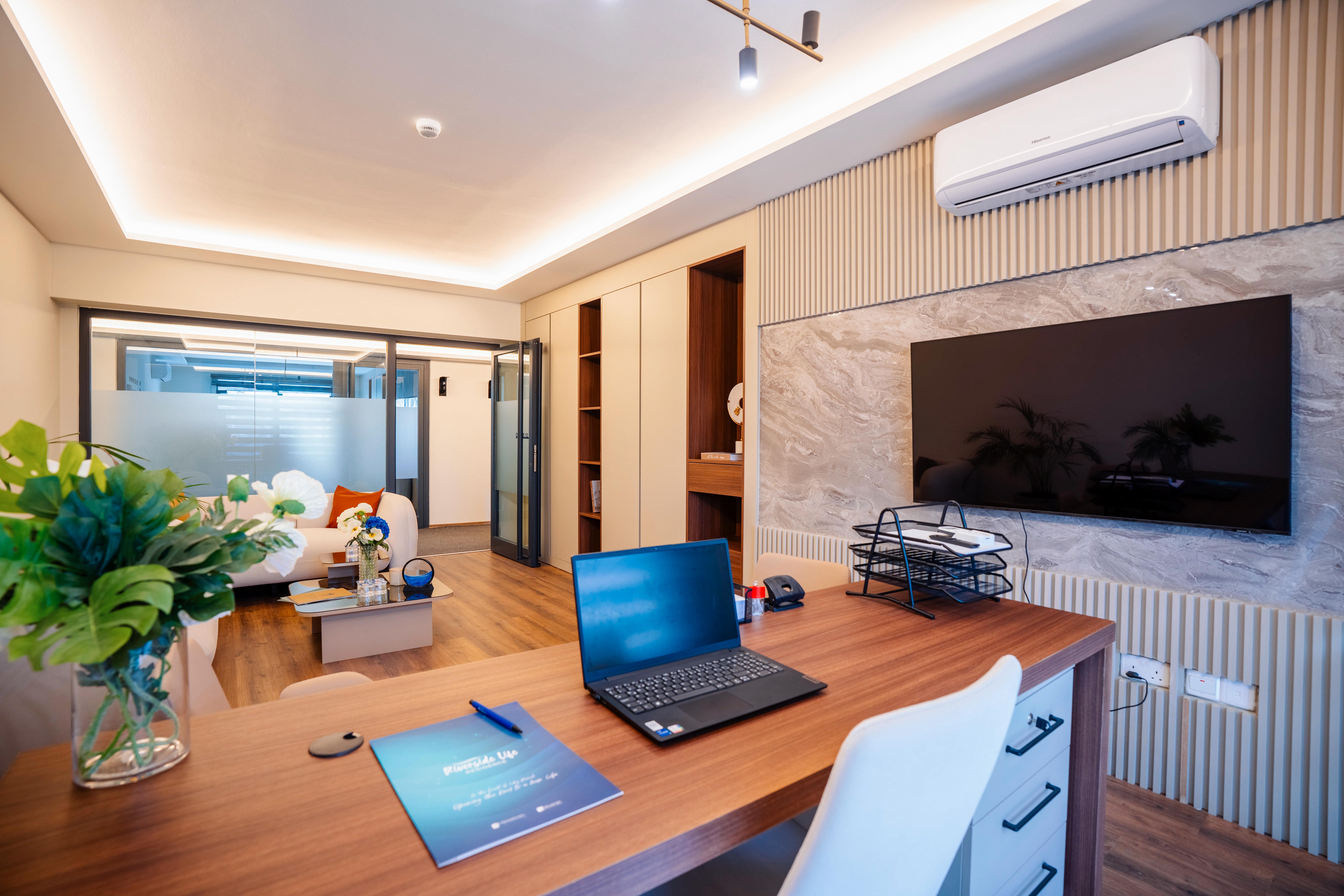 Executive office with walnut desk, TV, and lounge area